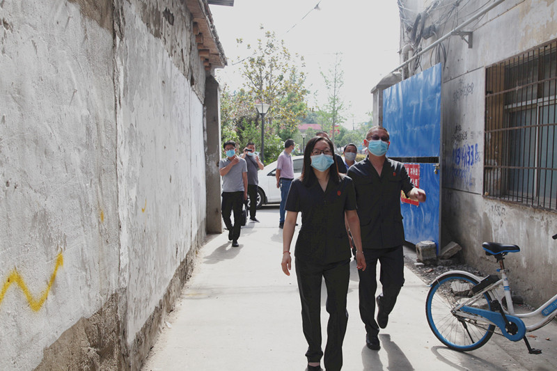 图①：执行局负责人罗兢（左一）和执行干警郑元斌（右一）到抵押房屋楼下_副本.jpg